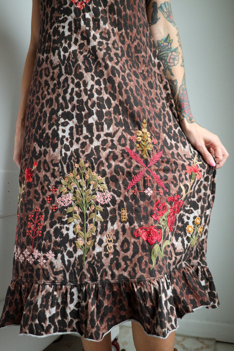 Dress with leopard print and floral embroidery on a plain background