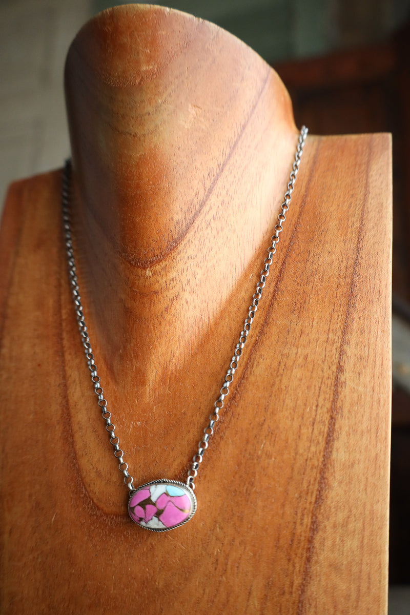 Necklace with a pink pendant on a wooden mannequin