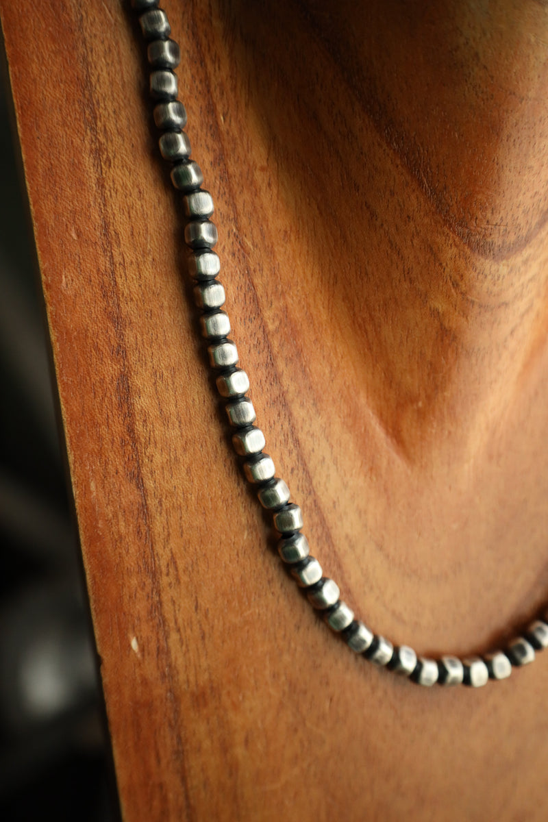 Necklace with black and white beads on a wooden surface