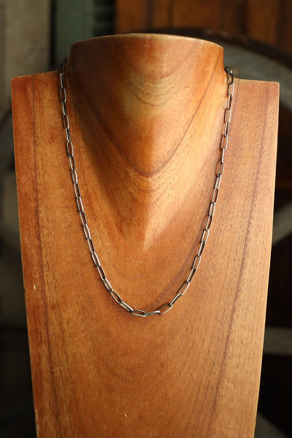 Silver chain necklace on a wooden mannequin bust