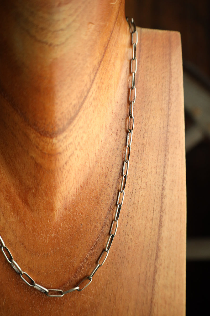 Silver chain necklace on a wooden surface