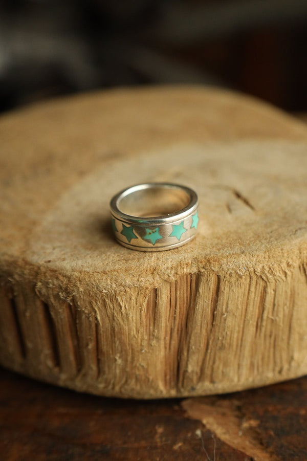 Silver ring with turquoise stones on a wooden surface