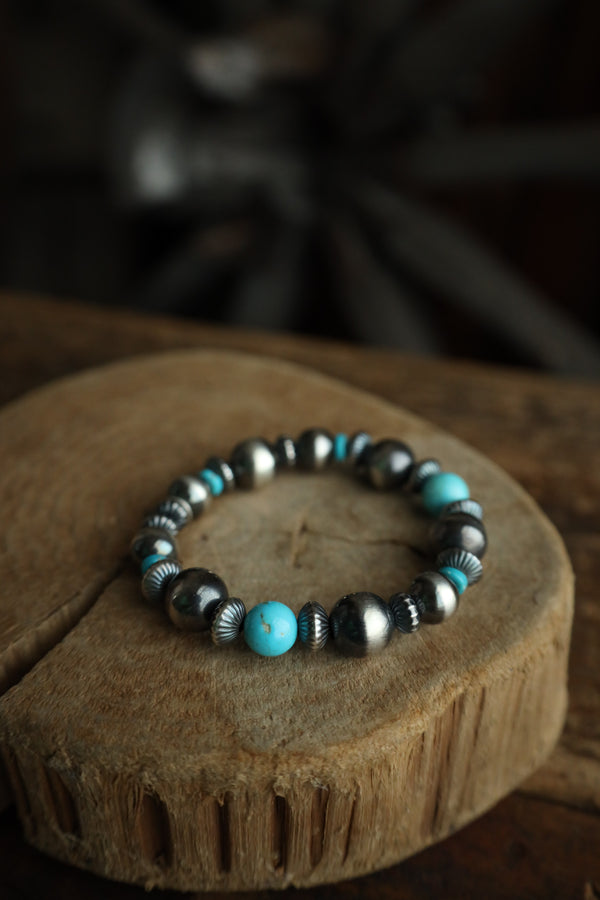 Bracelet with turquoise and silver beads on a wooden surface