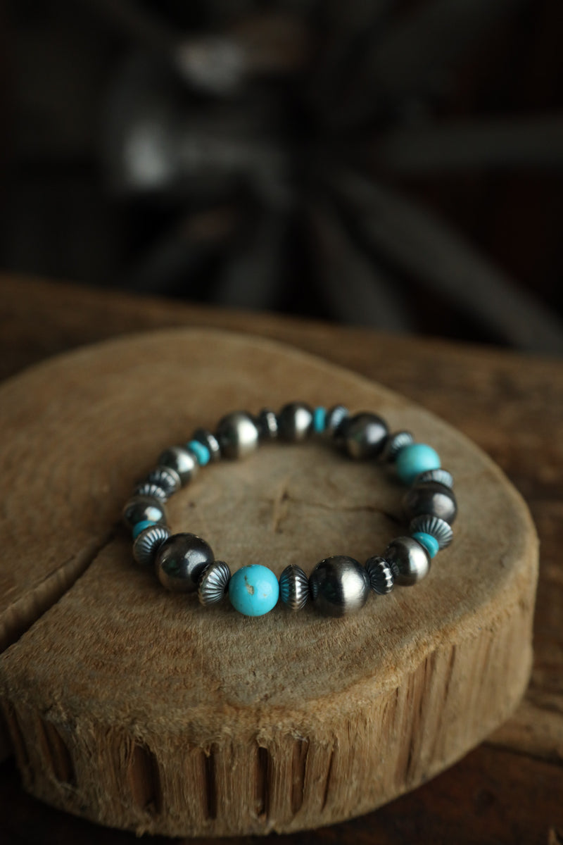 Bracelet with turquoise and silver beads on a wooden surface