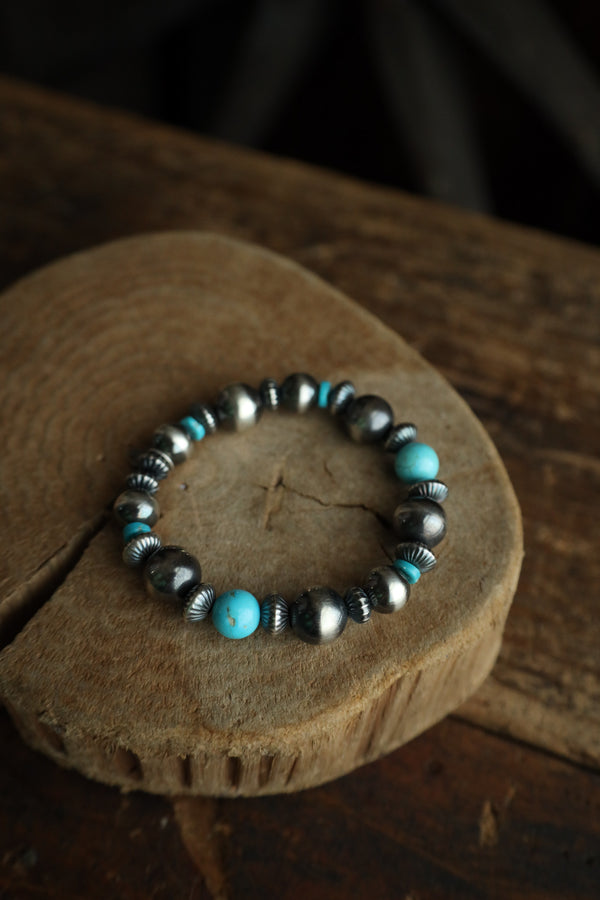 Bracelet with turquoise and silver beads on a wooden surface