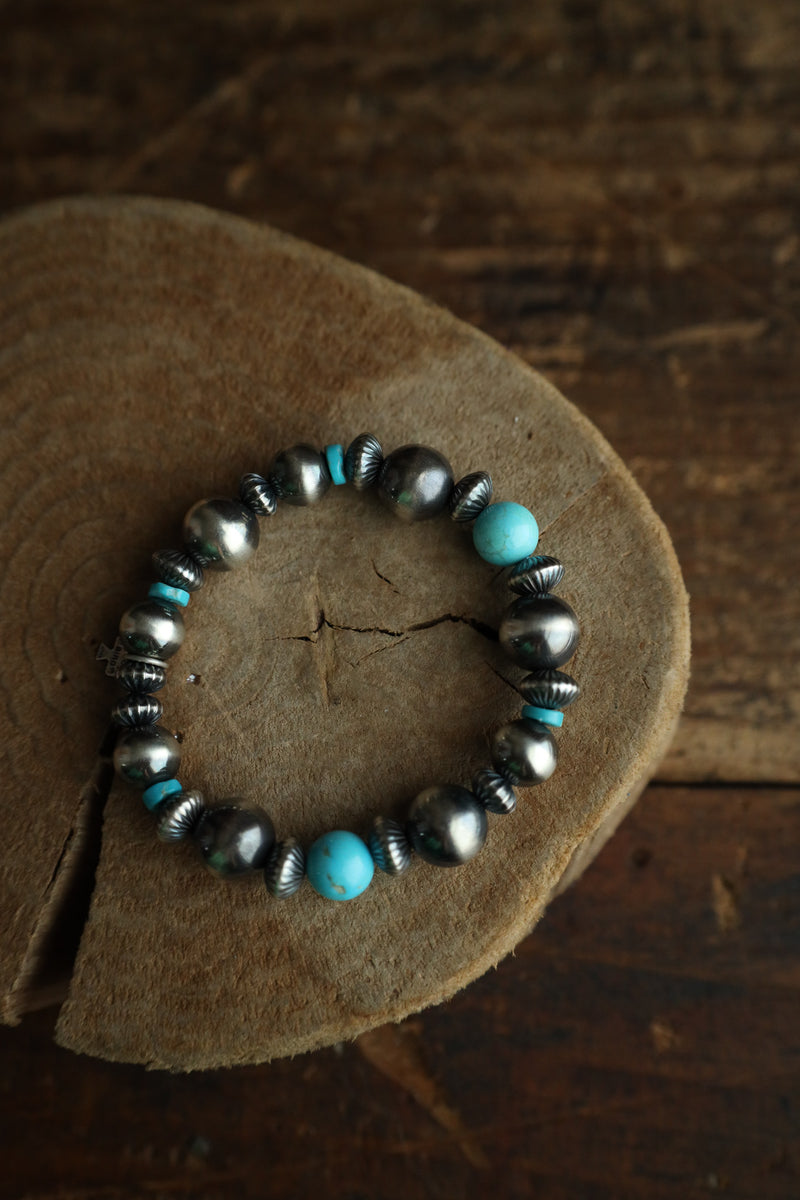 Bracelet with turquoise and silver beads on a wooden surface