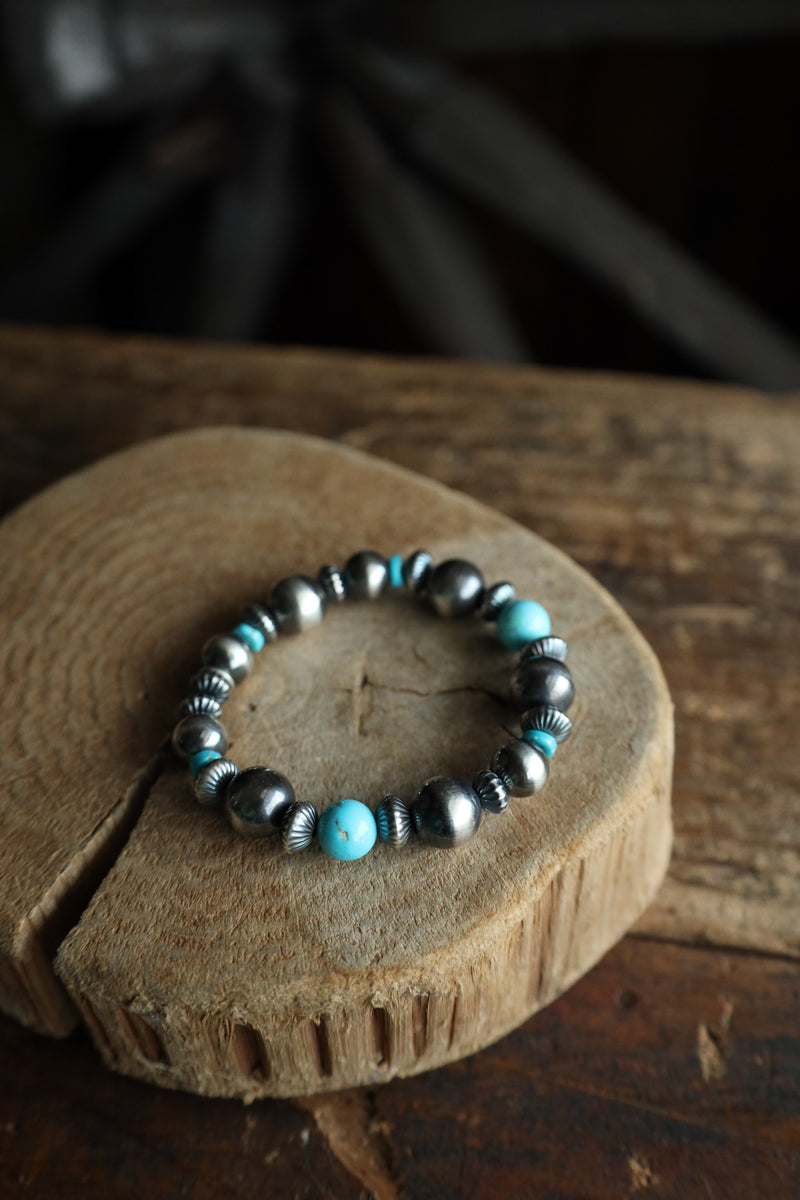 Beaded bracelet with turquoise and black beads on a wooden surface