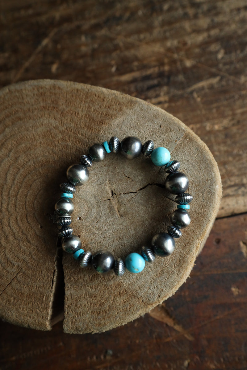 Bracelet with turquoise and silver beads on a wooden surface