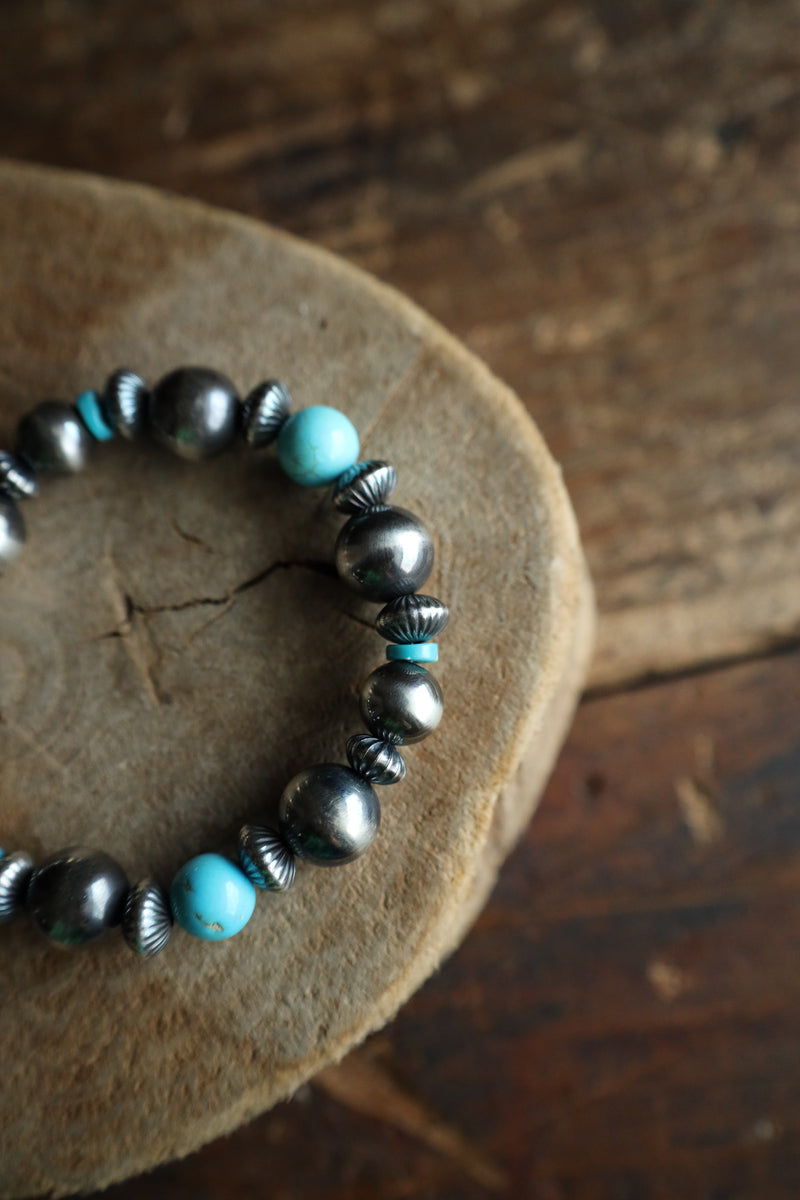 Bracelet with turquoise and silver beads on a wooden surface