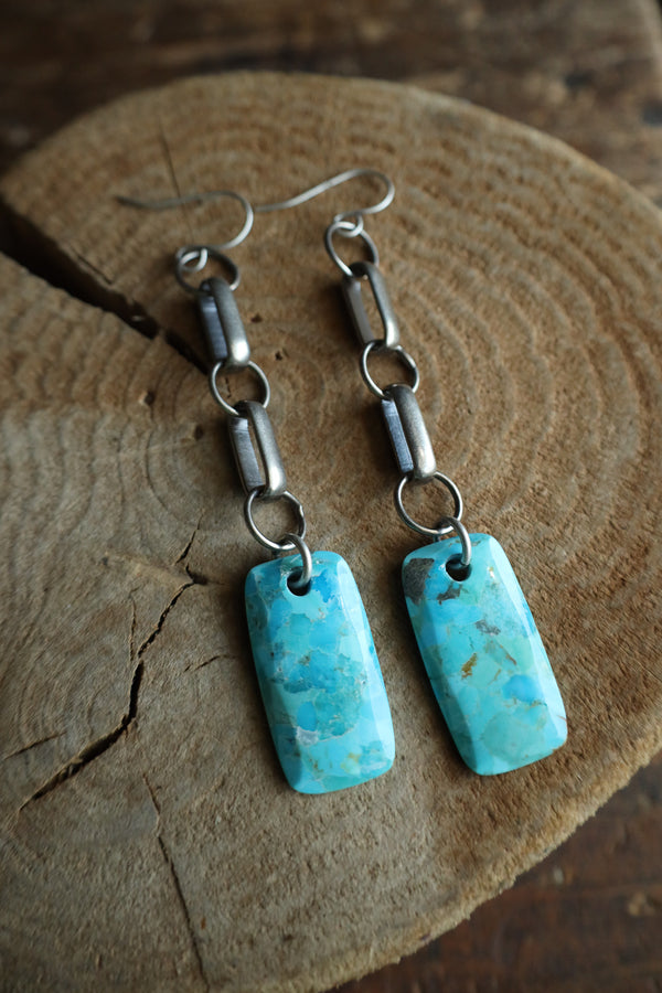 Turquoise earrings on a wooden surface