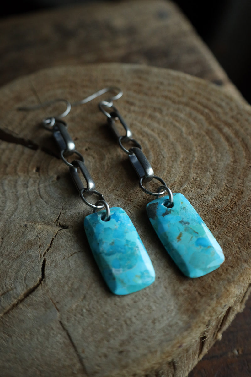 Turquoise earrings on a wooden surface