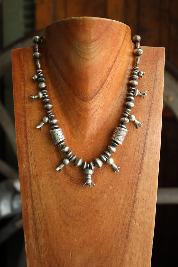 Silver beaded necklace on a wooden stand