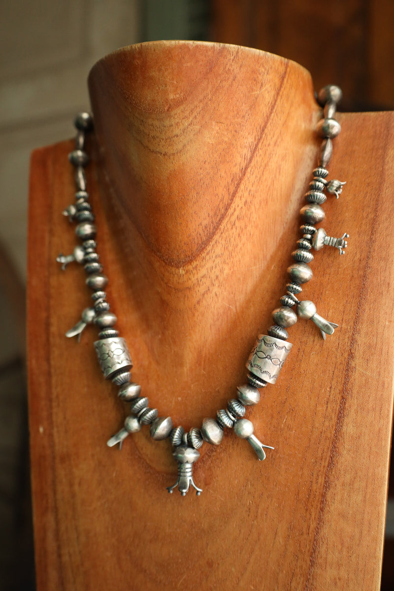 Silver beaded necklace on a wooden mannequin