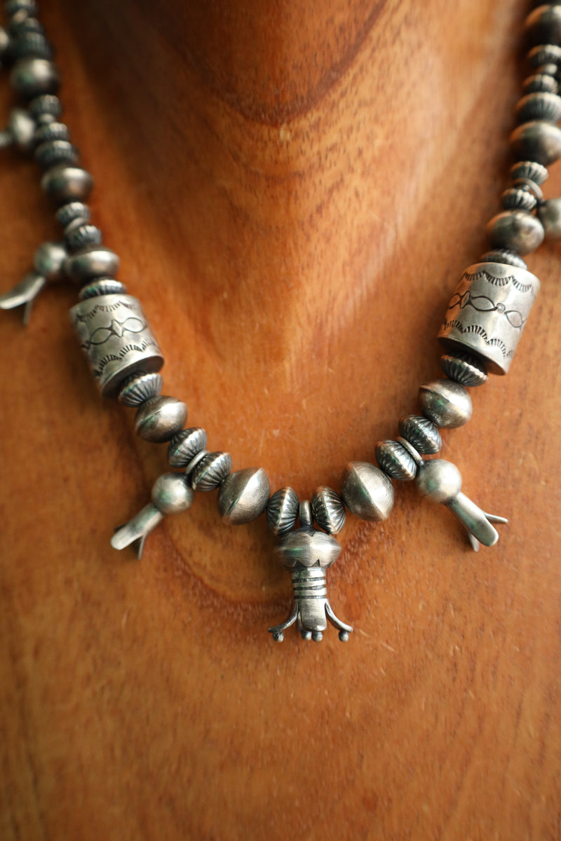 Silver beaded necklace on a wooden surface