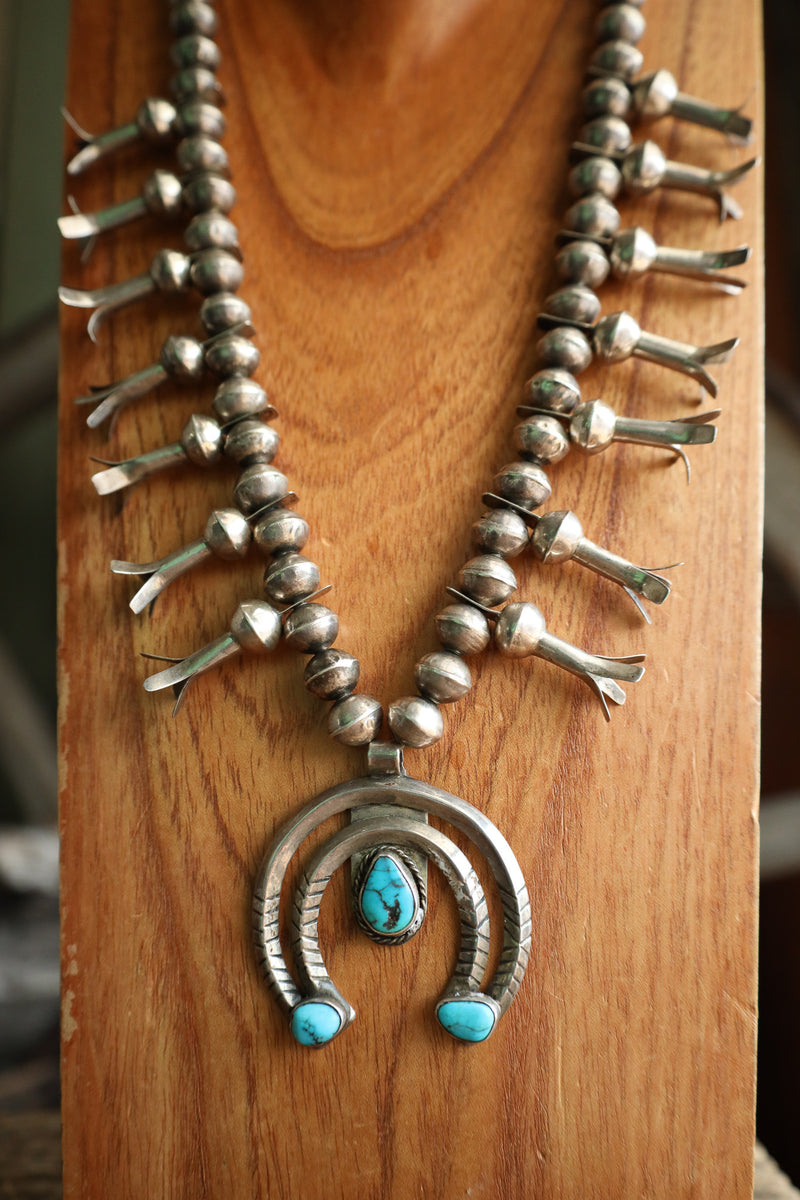 Silver necklace with turquoise stones on a wooden surface