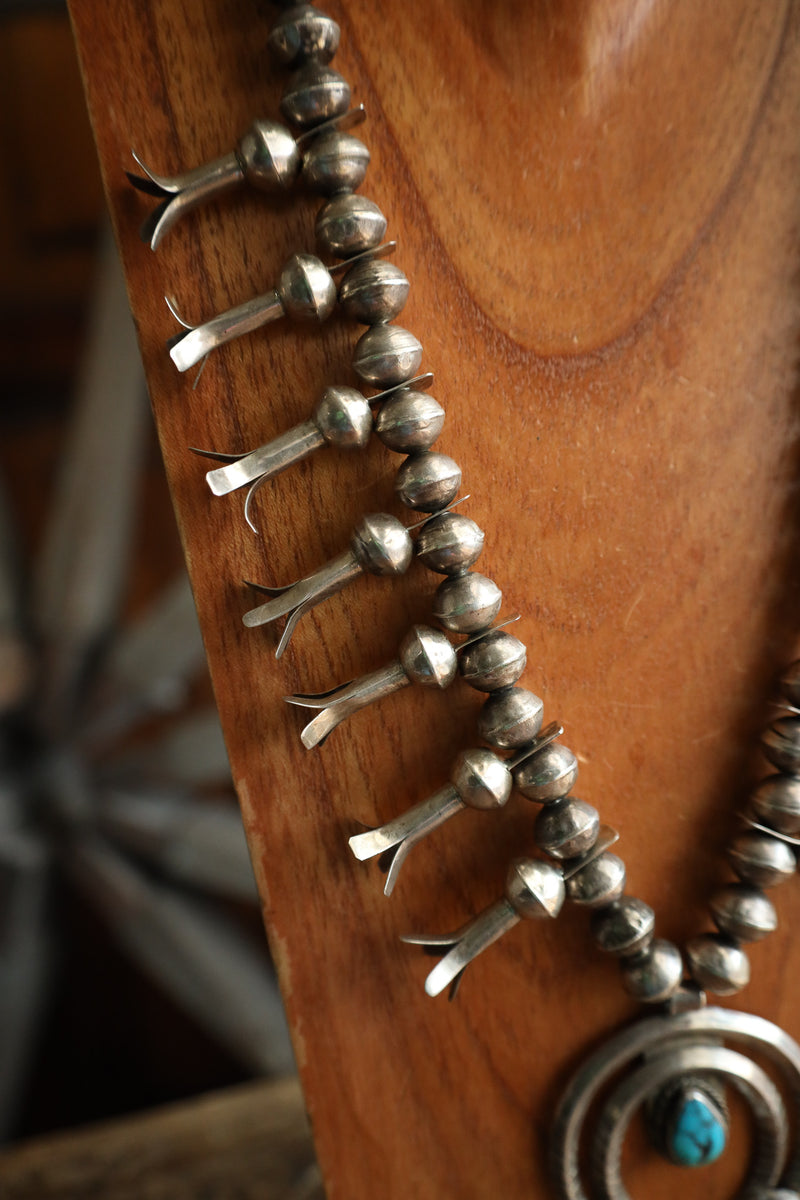 Close-up of a silver necklace with a wooden background