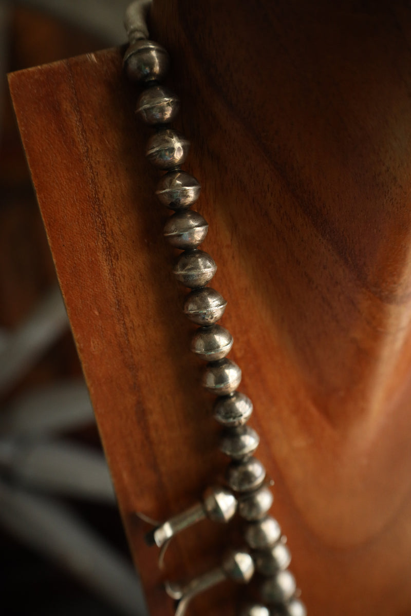 Close-up of a silver beaded earring on a wooden surface