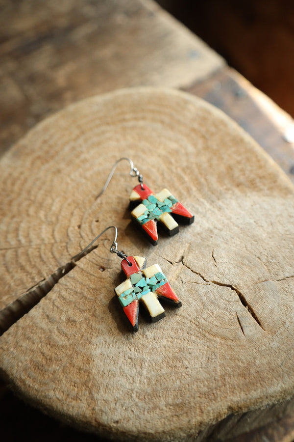 Pair of colorful geometric earrings on a wooden surface