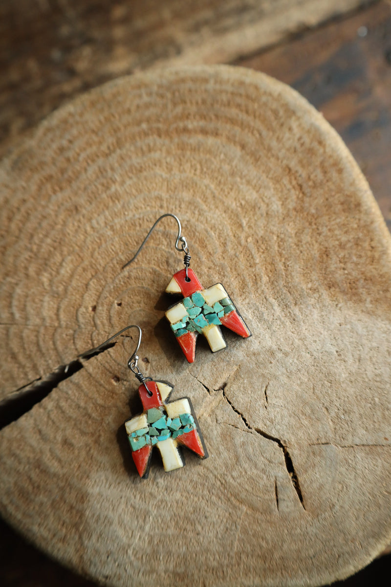 Pair of colorful earrings on a wooden surface