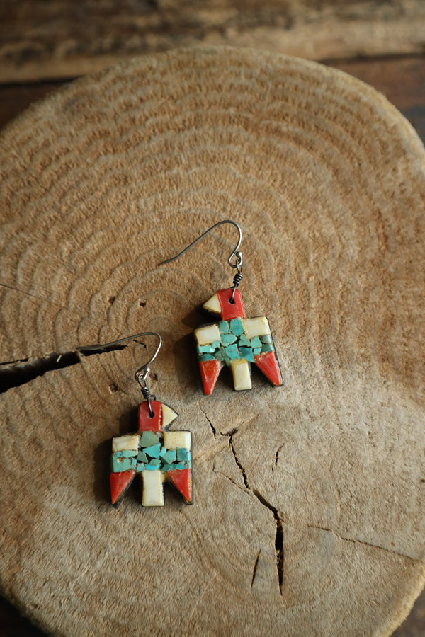 Colorful geometric earrings on a wooden surface