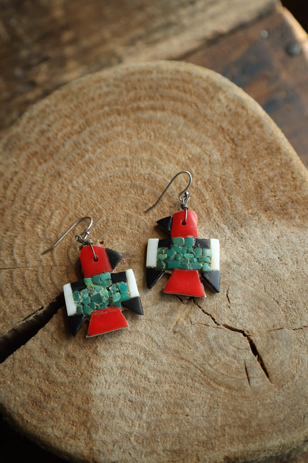 Pair of colorful earrings on a wooden surface