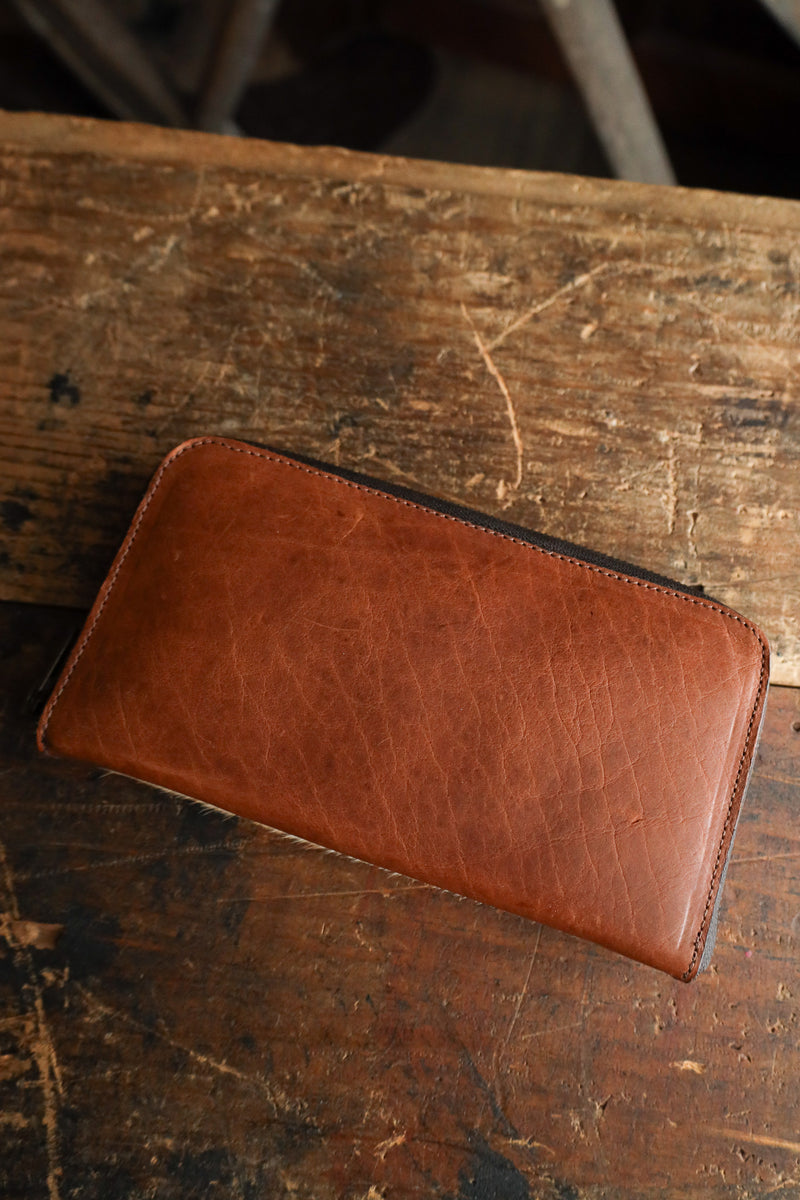 Brown leather wallet on a rustic wooden surface