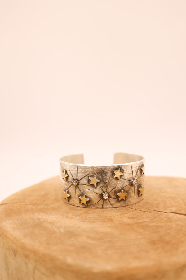 Sterling silver hammered cuff with eight 14 karat gold stars and three dazzling diamonds with rays engravings.