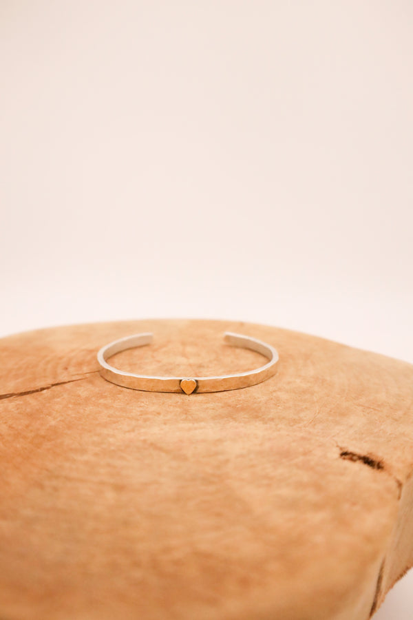 Hammered sterling silver cuff topped with a 14K gold heart