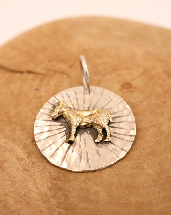 Sterling silver hammered circle pendant with 14K gold donkey in the center and rays engraved behind it