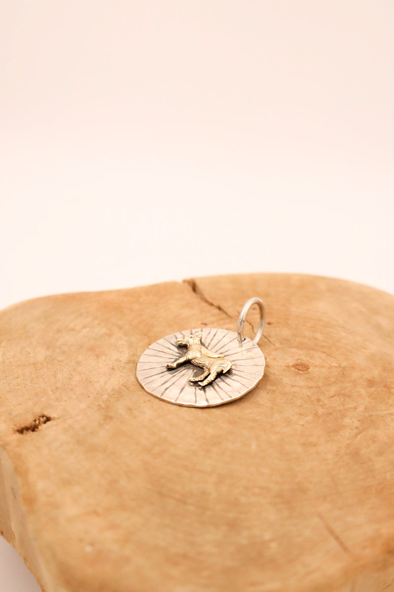 Sterling silver hammered circle pendant with 14K gold donkey in the center and rays engraved behind it