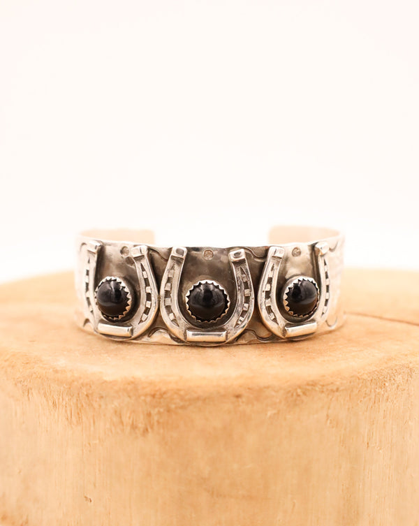 Sterling silver hammered bracelet with sterling silver horse shoes with onyx dots in the center