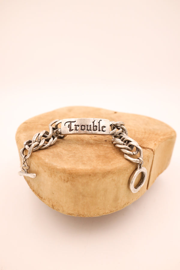 Sterling silver bracelet with script "trouble" on an ID tag