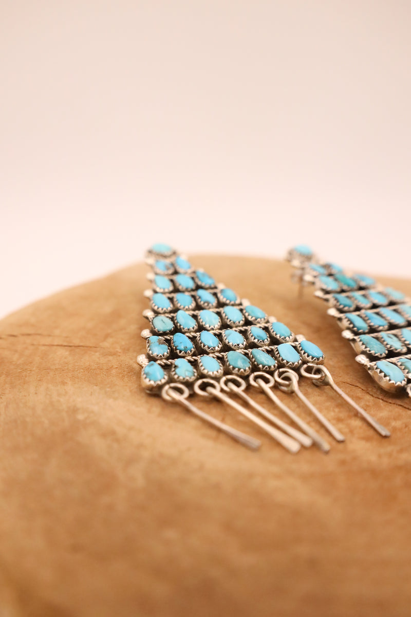 Sterling silver and turquoise earrings in the shape of a triangle with sterling silver dangles at the end