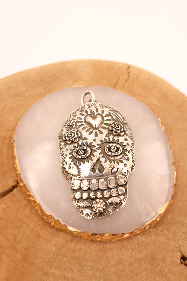 Sterling silver sugar skull with hand stamped details and a 14K gold heart in the center of the head