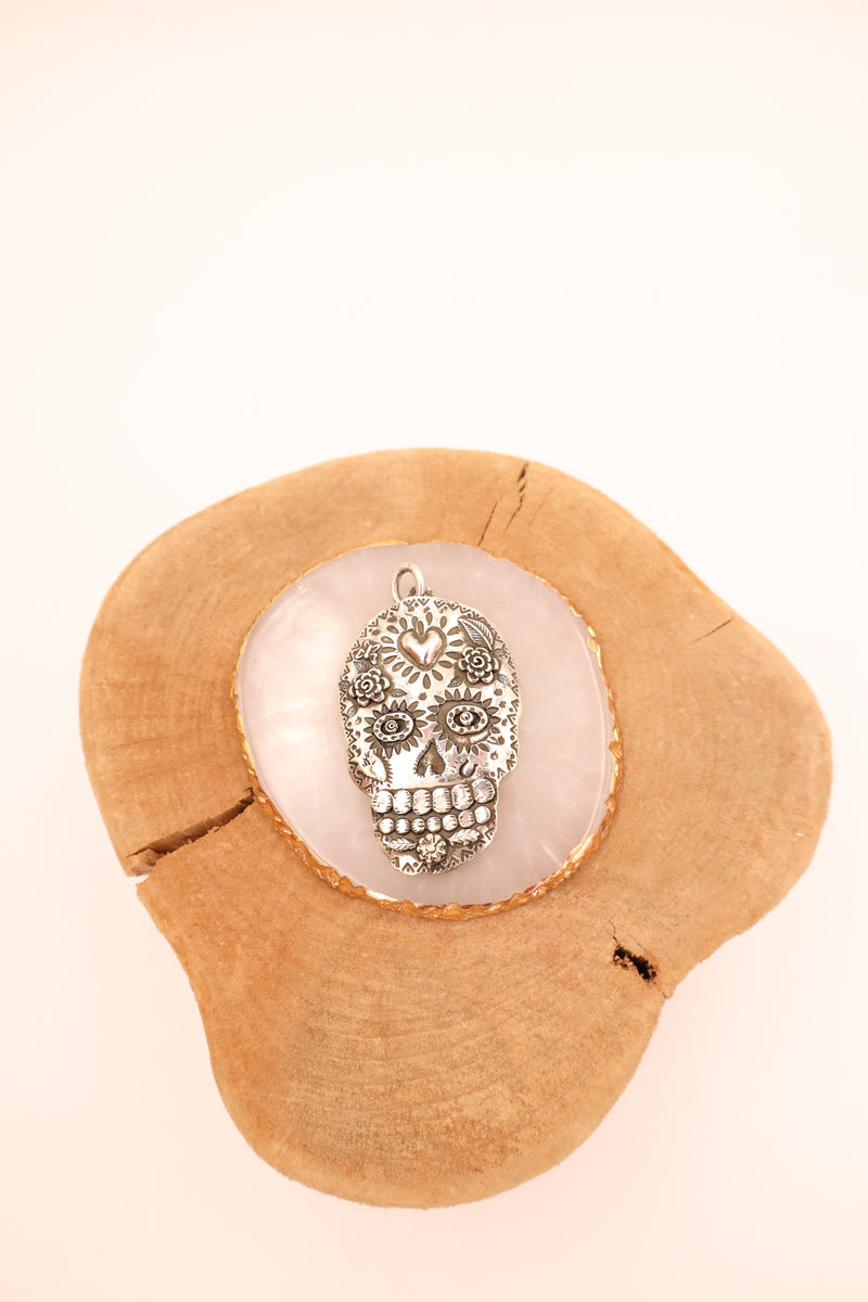 Sterling silver sugar skull with hand stamped details and a 14K gold heart in the center of the head
