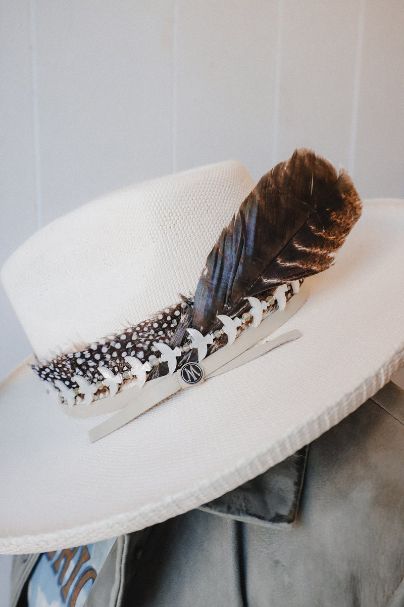 Black and white dot feather hat band with leather straps in the back to secure to any cowboy hat