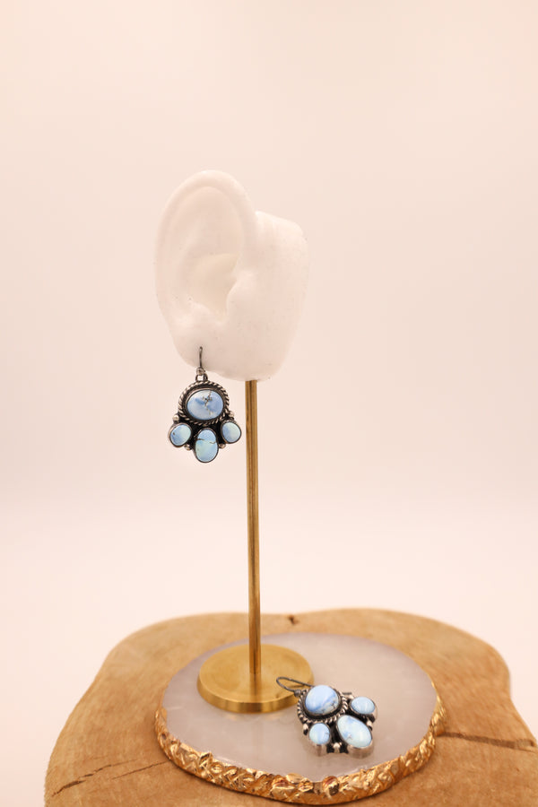 Each earring features four vibrant turquoise stones set in a sterling silver bezel