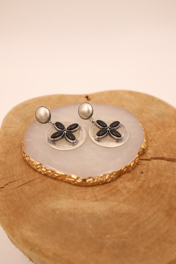 Earrings crafted with sterling silver, this western jewelry piece features a stunning onyx sun cross at its center