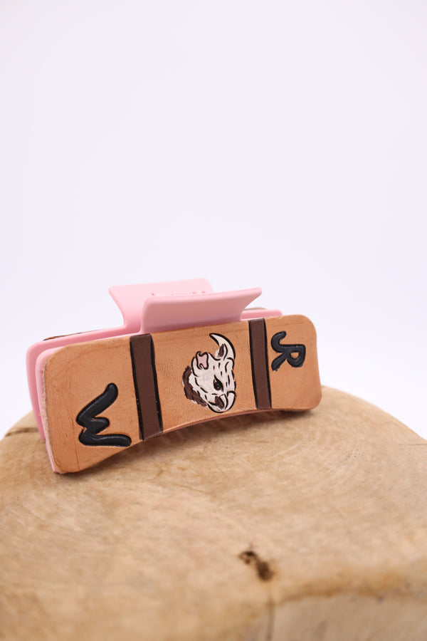 Pink claw clip with hand tulled leather with image of cow and brands on either side