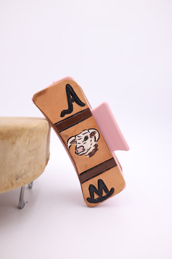 Pink claw clip with hand tulled leather with image of cow and brands on either side