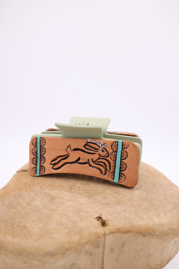 Light green leather tooled claw clip with image of jackalope with daisies on both sides