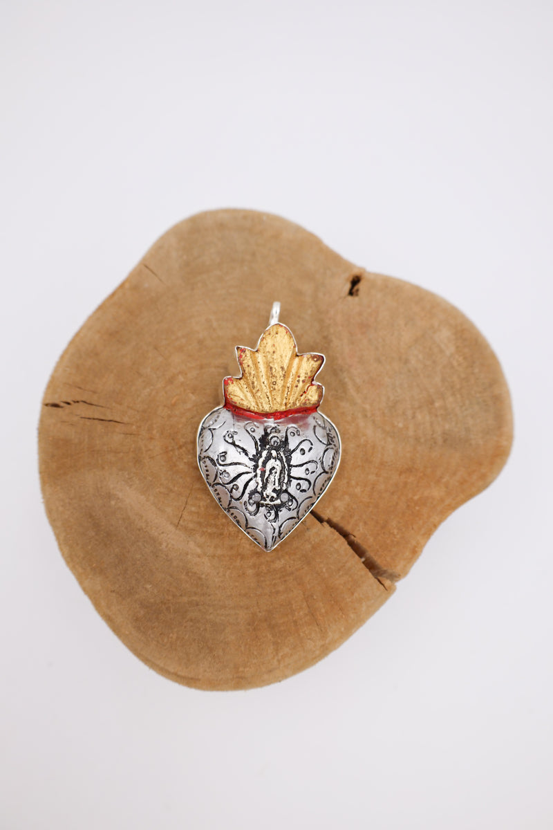 Wooden heart with golden flames and a Guadalupe milagro in the center.