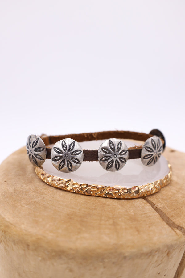 Leather cinch bracelet with sterling silver concho charms.