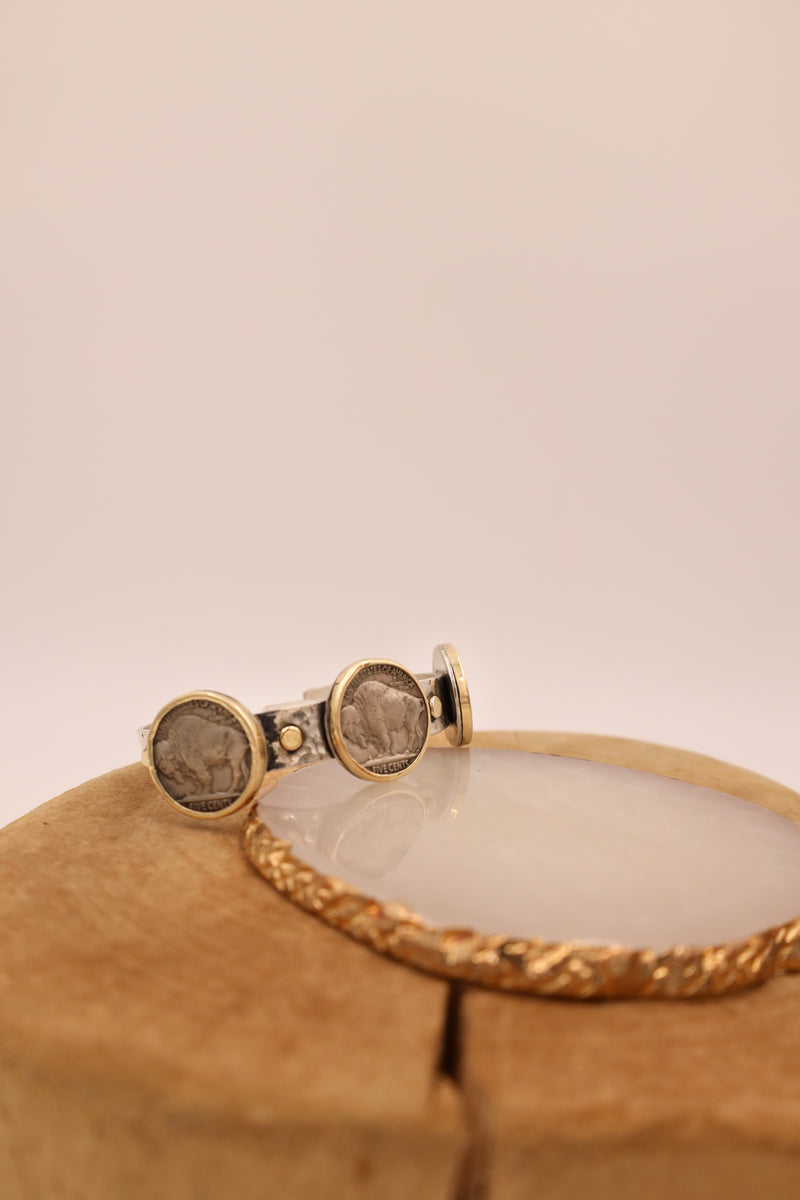 Sterling silver hammered cuff with three buffalo nickels with gold rims and gold dots in between the coins