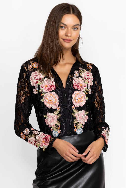 Woman wearing blouse with a combination of detailed lace and colorful floral bouquets with button front and long sleeves