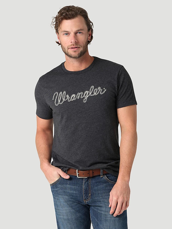 Man wearing charcoal shirt with script "Wrangler" made of rope in the center