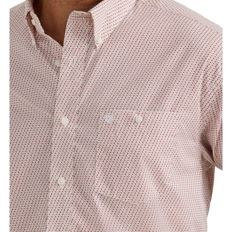 Man wearing long sleeved button down with red and white pattern and single button breast pocket