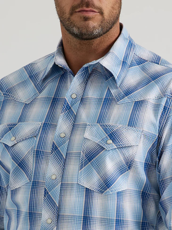 Man wearing blue plaid button down long sleeve shirt with double breast pockets on front and western yoke on shoulders and back