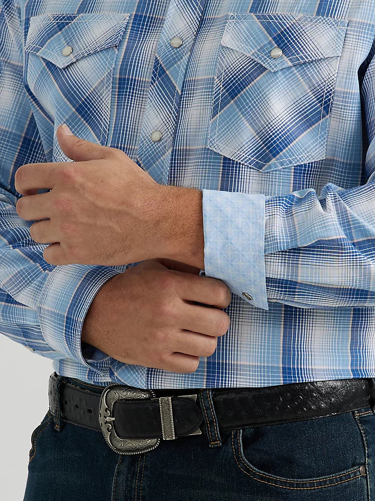 Man wearing blue plaid button down long sleeve shirt with double breast pockets on front and western yoke on shoulders and back