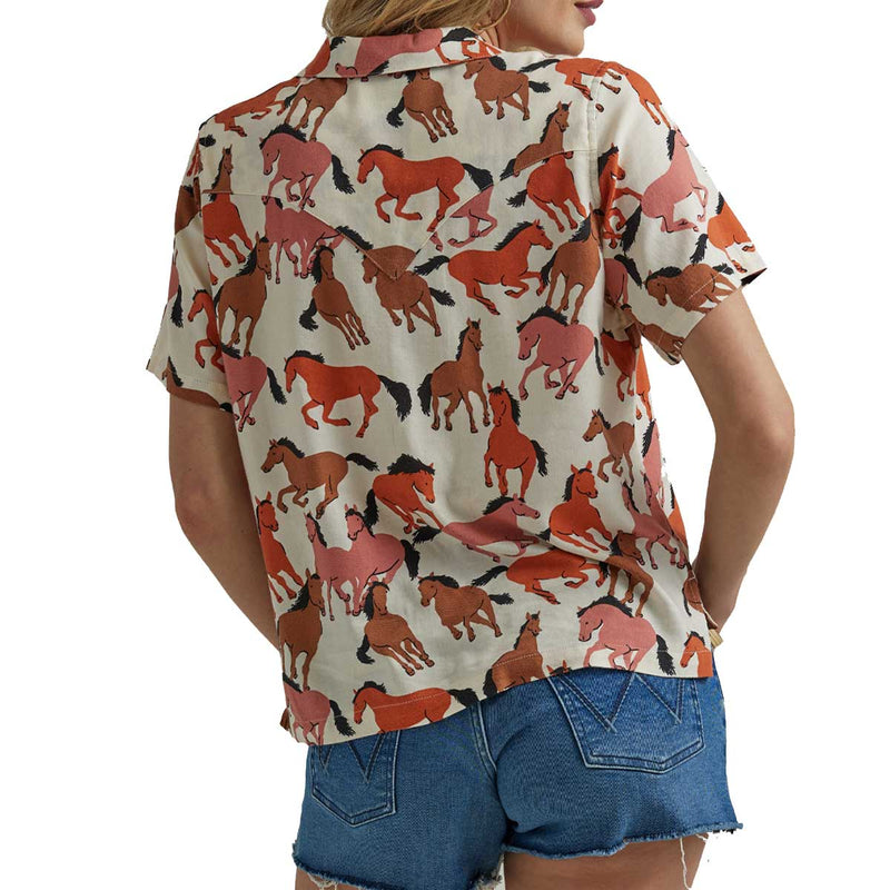 Woman wearing button up short sleeve shirt with orange and brown horses all over it